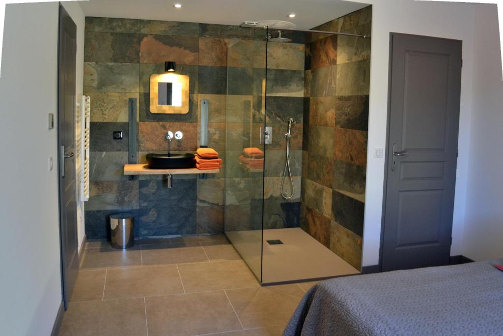 a bathroom with a shower with a glass door at Les Chêneslierres in Lourmarin