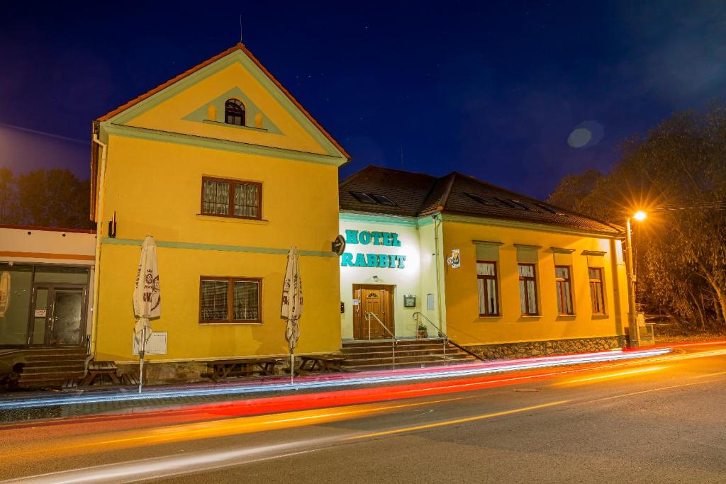 a yellow building on the side of a street at night at Hotel Rabbit in Trhový Štěpánov