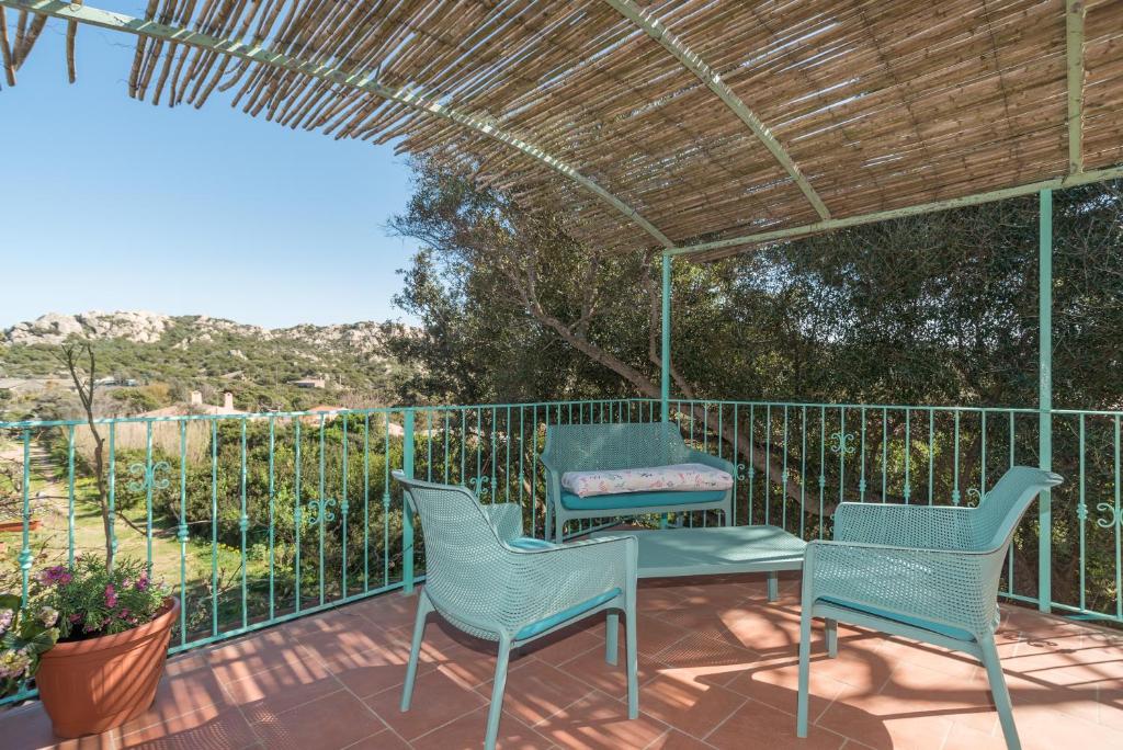 eine Terrasse mit Stühlen, einem Tisch und einem Zaun in der Unterkunft Casa Marina in La Maddalena