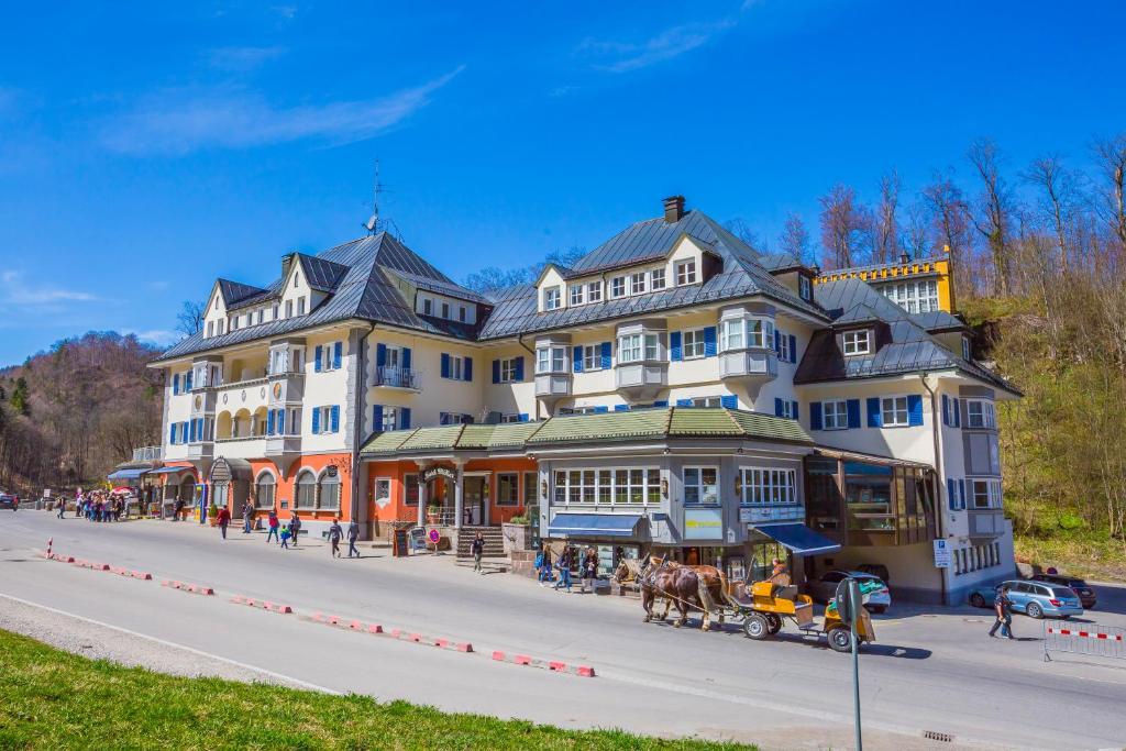 un grande edificio con una carrozza trainata da cavalli di fronte ad esso di Hotel Müller a Hohenschwangau
