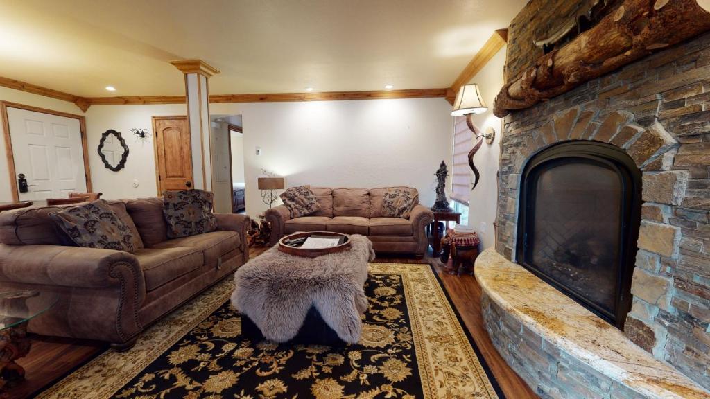 a living room with couches and a stone fireplace at Mammoth Estates Deluxe 2 Bedroom Condos in Mammoth Lakes