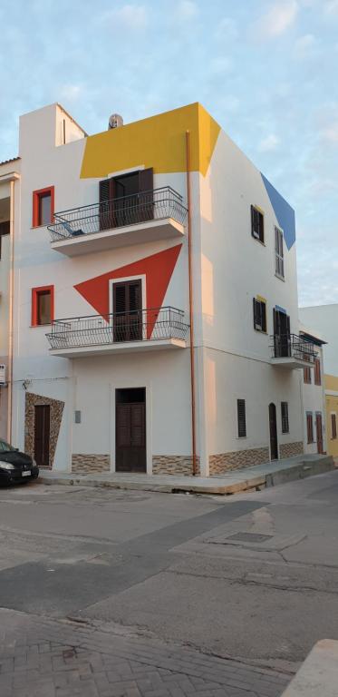 un edificio bianco e arancione con balconi di RgB_Apartments a Lampedusa