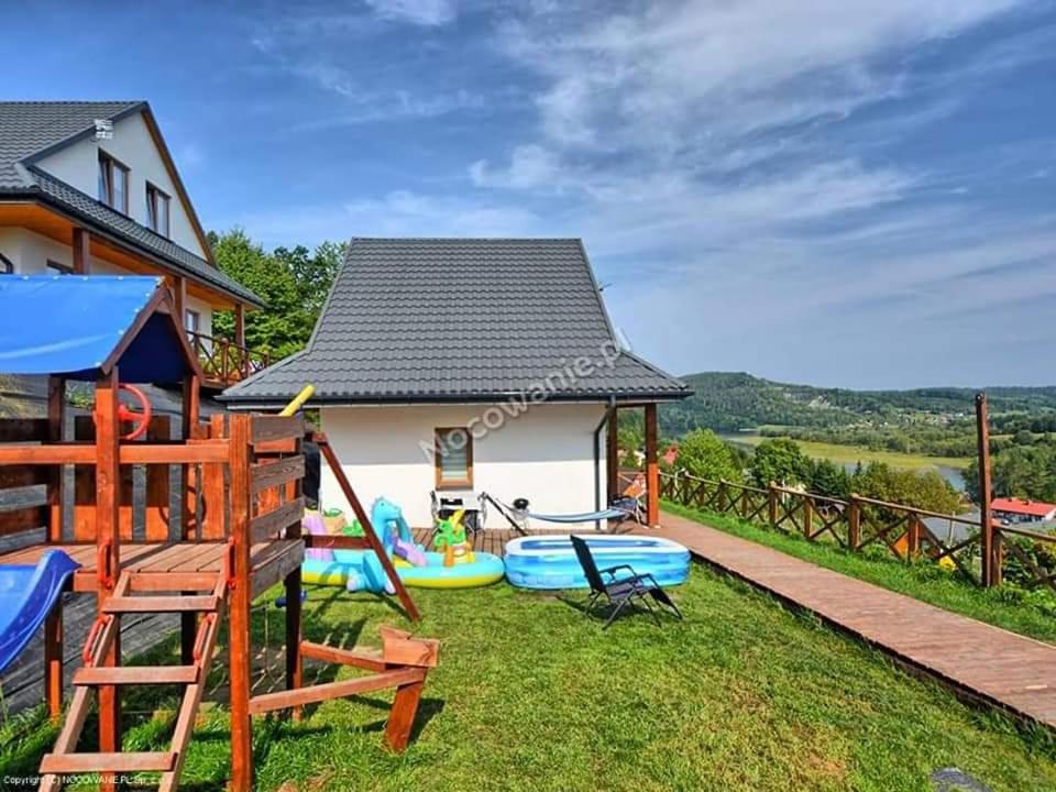 a house with a playground in the yard at Domki Solina Róża Wiatrów in Solina