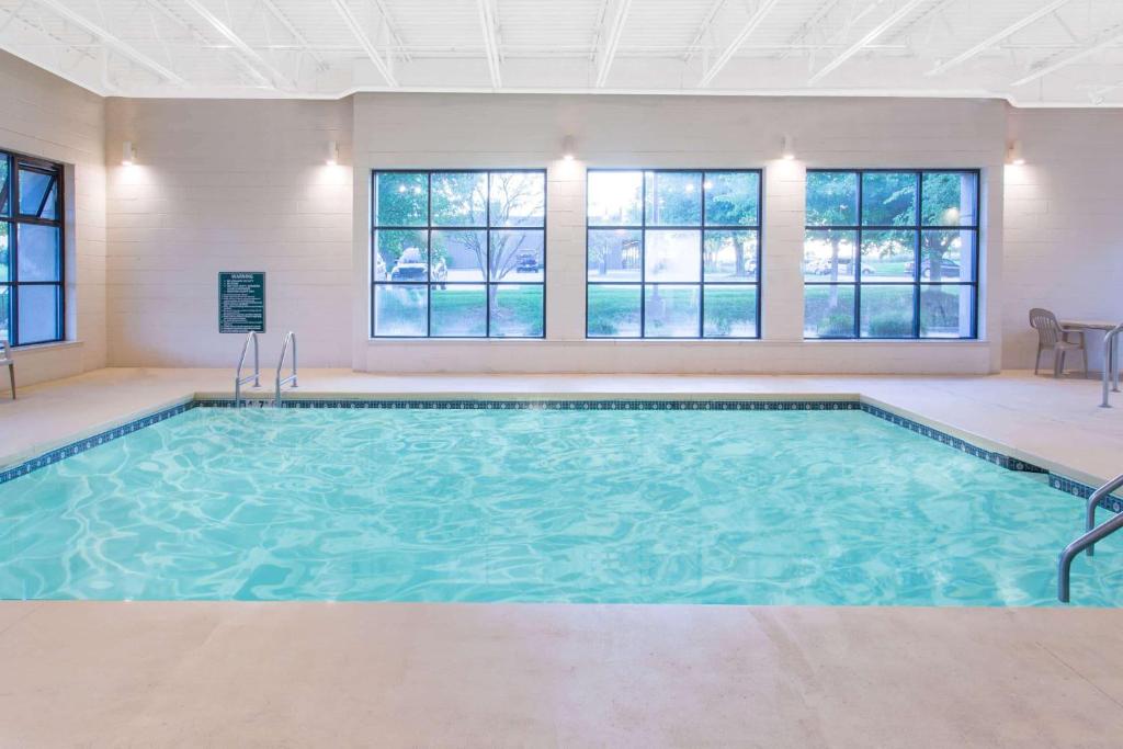 a swimming pool in a room with windows at Baymont by Wyndham Davenport in Davenport