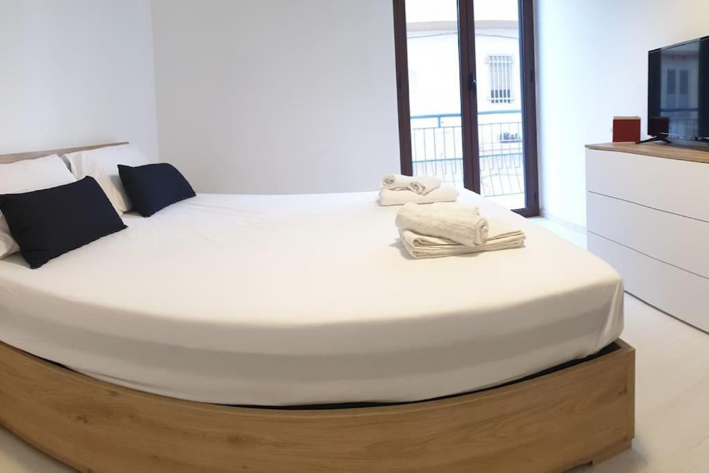 a large white bed in a room with a tv at RgB_Apartments in Lampedusa