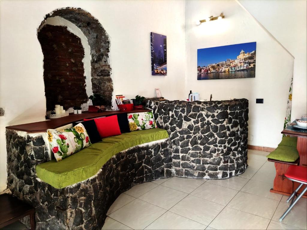 kanapa wykonana z kamiennej ściany w pokoju w obiekcie La Casa Doro w Katanii