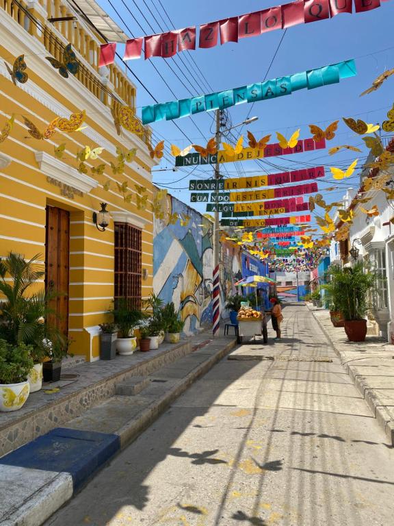 uma rua numa cidade com bandeiras penduradas em edifícios em CASA PACHITA Getsemani em Cartagena das Índias