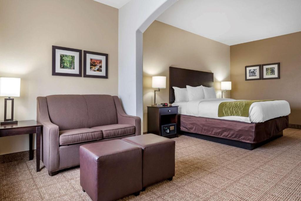 a hotel room with a bed and a chair at Comfort Inn & Suites Scott-West Lafayette in Scott