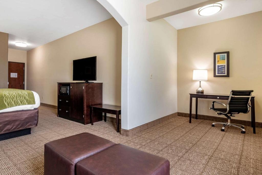 a hotel room with a bed and a desk and a chair at Comfort Inn & Suites Scott-West Lafayette in Scott