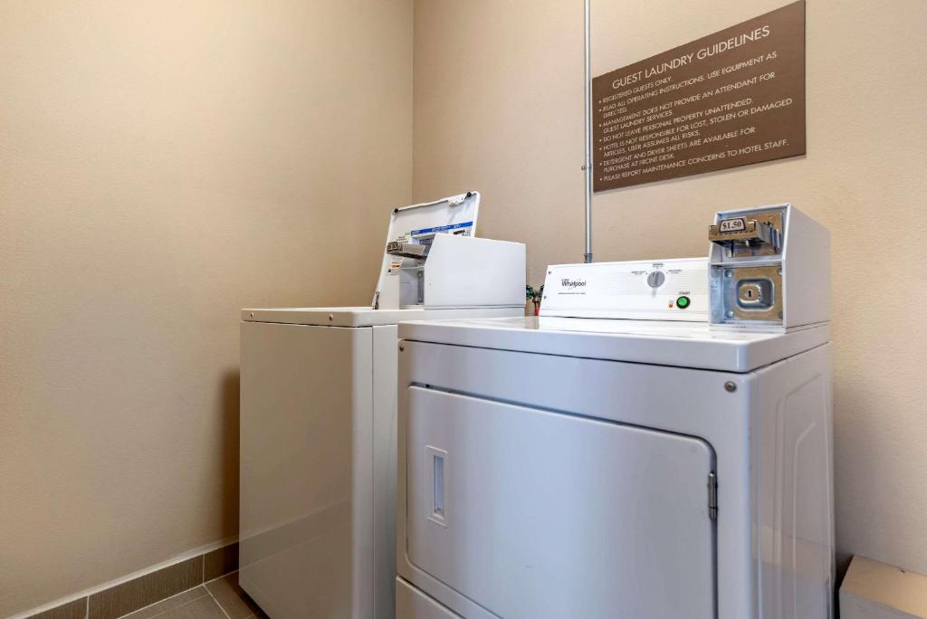 a laundry room with a washer and dryer and a sign at Comfort Inn & Suites Scott-West Lafayette in Scott