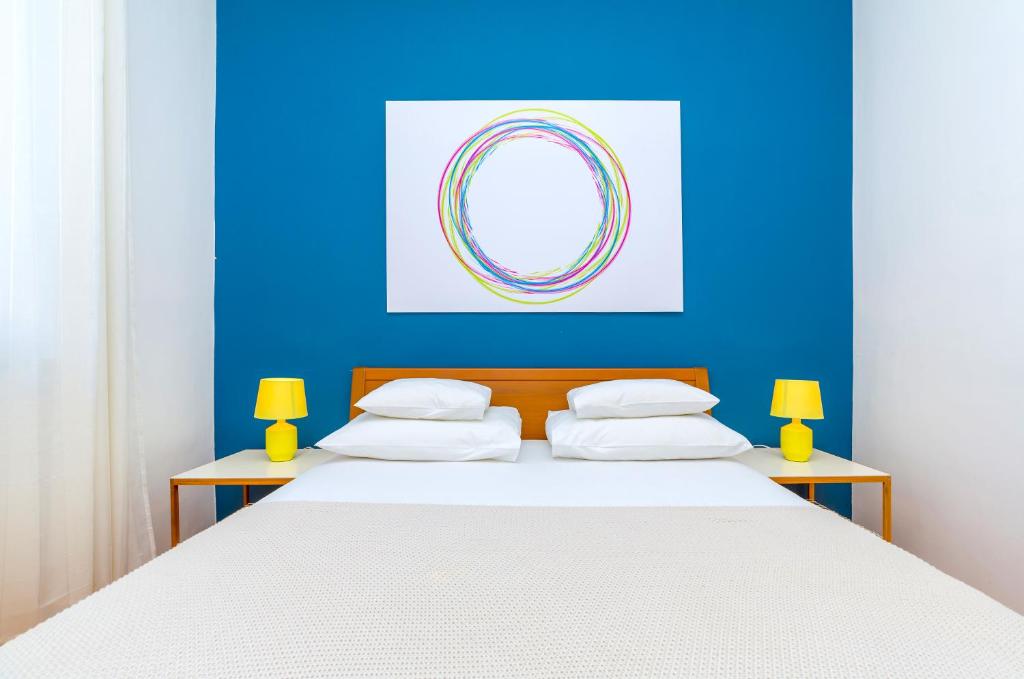 1 dormitorio con 1 cama blanca grande y pared azul en Lux Split Centre Apartments en Split