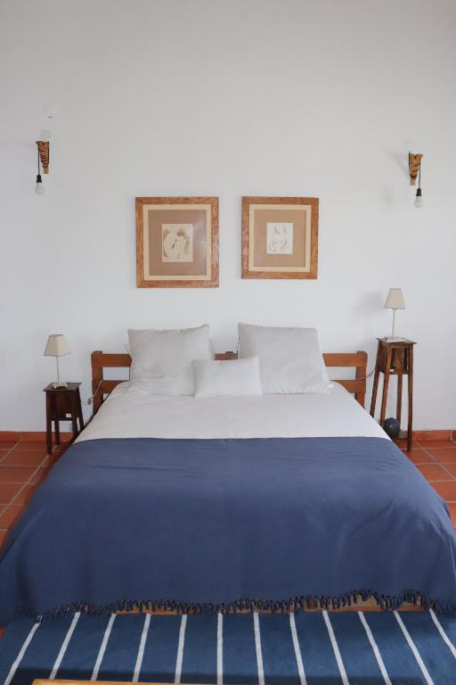 un letto con una coperta blu sopra di Casa do Alambique a Tomar