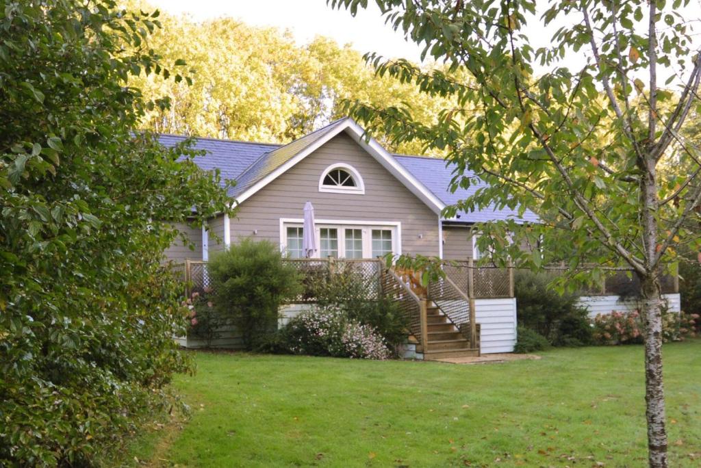una casa con un patio con césped verde en Brook Lodge en Colchester