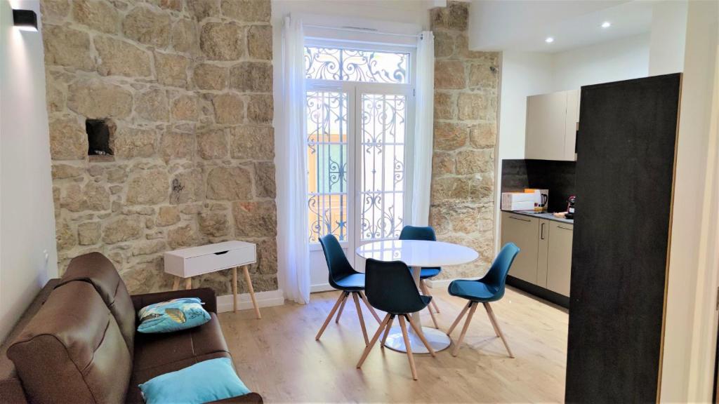 un salon avec un canapé, une table et des chaises dans l'établissement hypercentre lamartine 001, à Nice