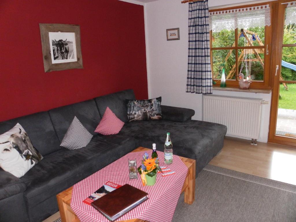 sala de estar con sofá negro y mesa en Landhaus Schmid, en Oberstdorf