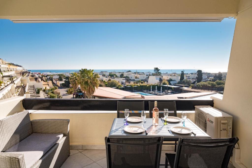 - une table avec des verres à vin sur un balcon avec vue dans l'établissement Studio Village Naturiste Spy on me, au Cap d'Agde