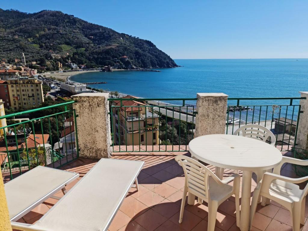 balkon ze stołem i krzesłami oraz oceanem w obiekcie Maia Incantevole w mieście Levanto