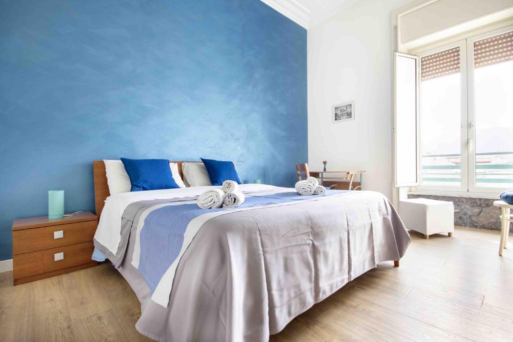 1 dormitorio con 1 cama con pared azul en Casa Cavour, en Palermo