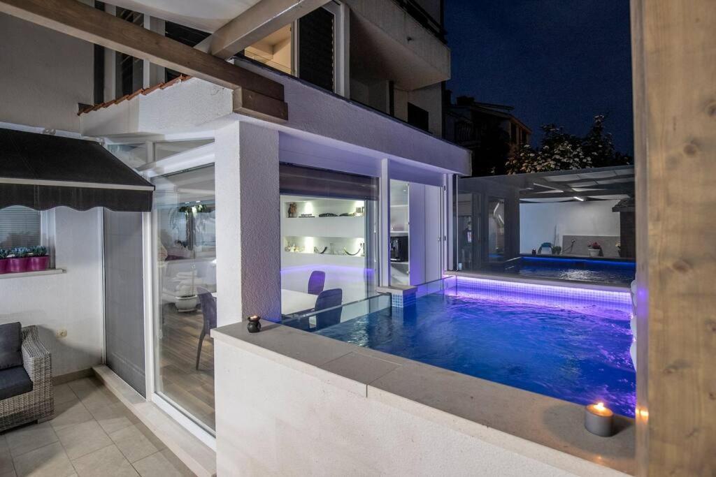 a swimming pool in a house at night at Luxury apartment Martinis with pool in Split