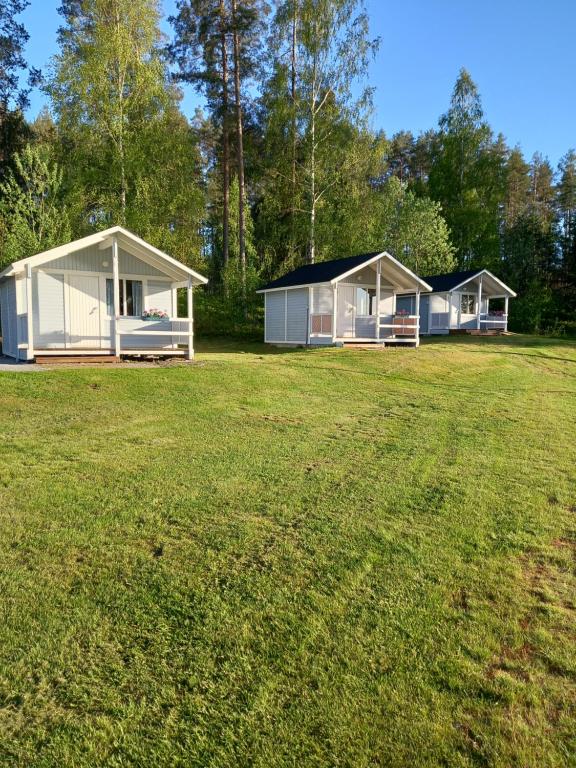 two mobile homes on a grassy field with trees at Santtioranta Camping in Uusikaupunki