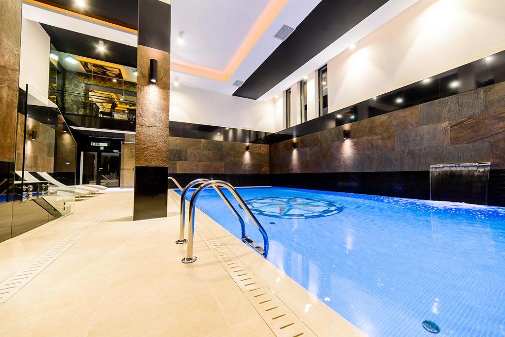 a large swimming pool in a hotel room at Arena Hotel Spa & Wellness in Tychy