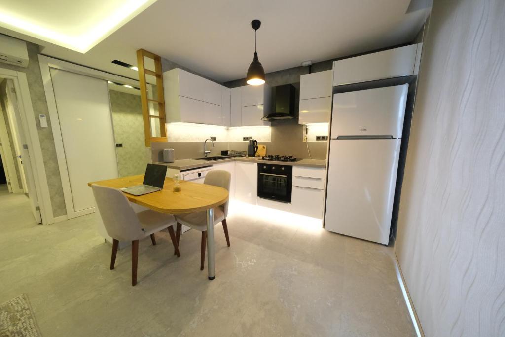 a kitchen with a wooden table with a laptop on it at Sky Garden Suites in Adana