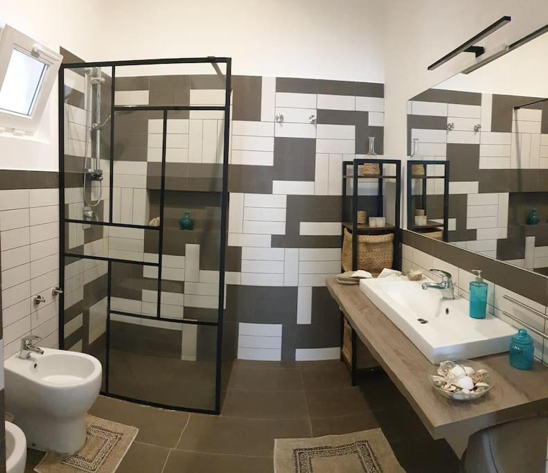 a bathroom with two sinks and a shower and a toilet at RgB_Apartments in Lampedusa