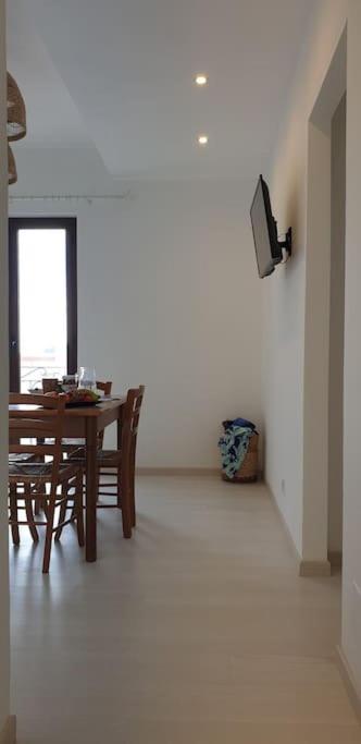 a dining room with a table and chairs and a television at RgB_Apartments in Lampedusa
