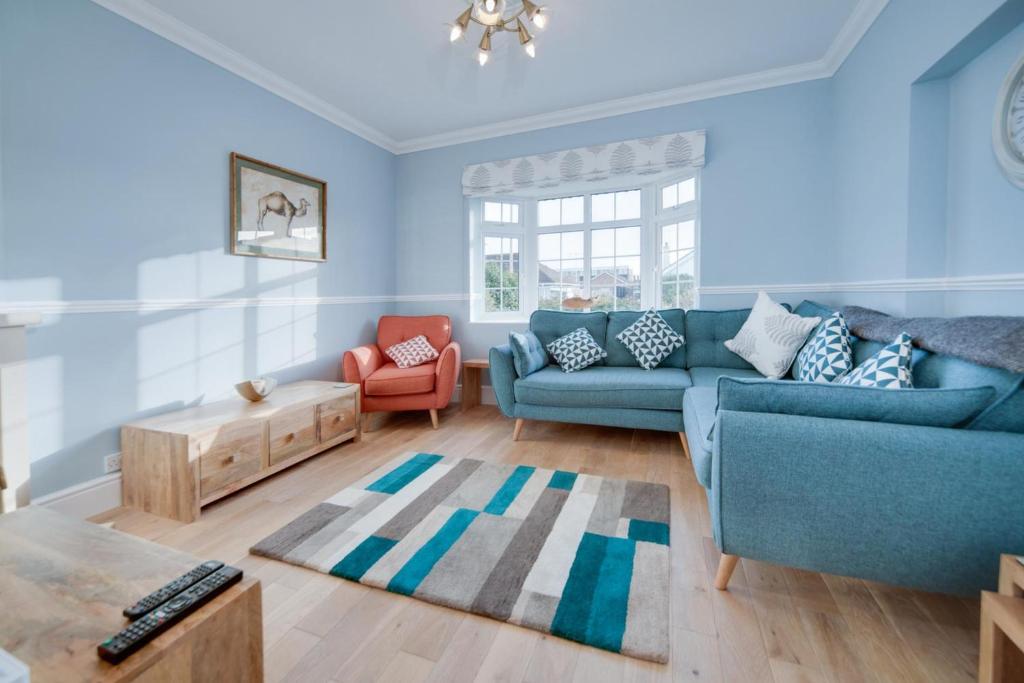 a living room with a blue couch and a table at Super 5 Bedroom Family Friendly Retreat Rustington in Littlehampton