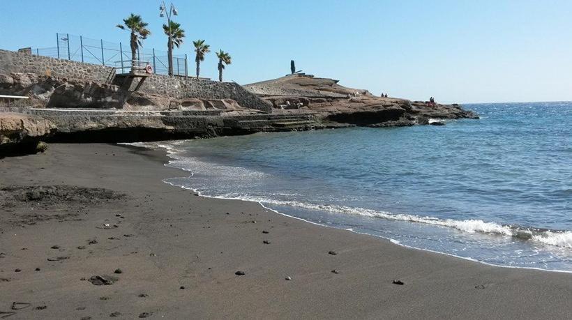 uma praia arenosa com palmeiras e o oceano em risveglio sull oceano wifi-parking-free em La Listada