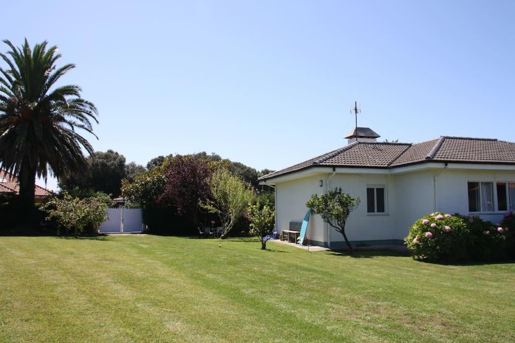 uma casa branca com uma palmeira e um quintal em Perfect Chalet for Beach Lovers and Golfers em Somo
