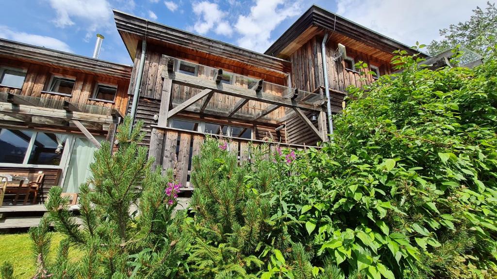 una casa de madera con un jardín delante de ella en Haus Emmy - Urlaub bei Freunden, en Hohentauern