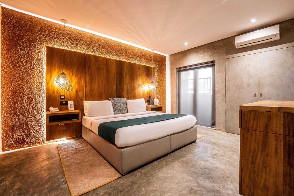 een slaapkamer met een bed met een houten muur bij The Borough Lagos in Lagos