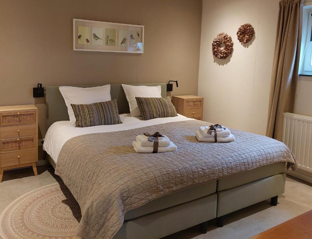 1 dormitorio con 1 cama con 2 toallas en Bed & Breakfast 't Boerenhart, en Duizel