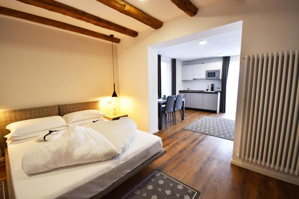una camera da letto con un letto e un soggiorno di Maison Boutique Fior d'Alpe a Sappada
