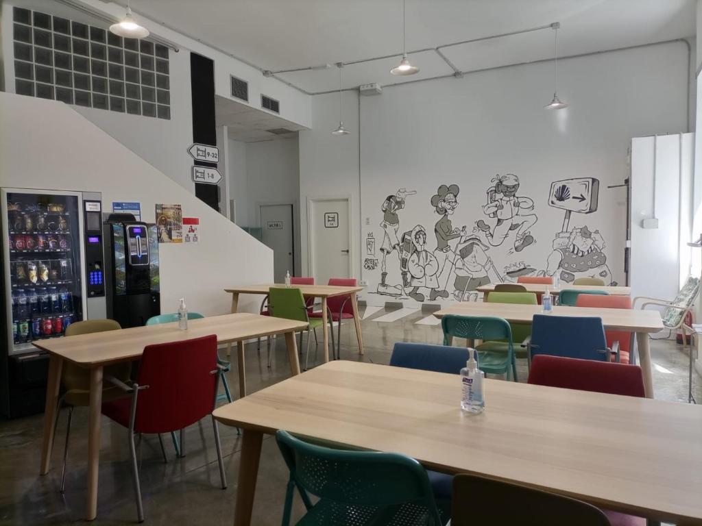 een restaurant met tafels en stoelen en een muurschildering bij Albergue Avoa Regina in Redondela