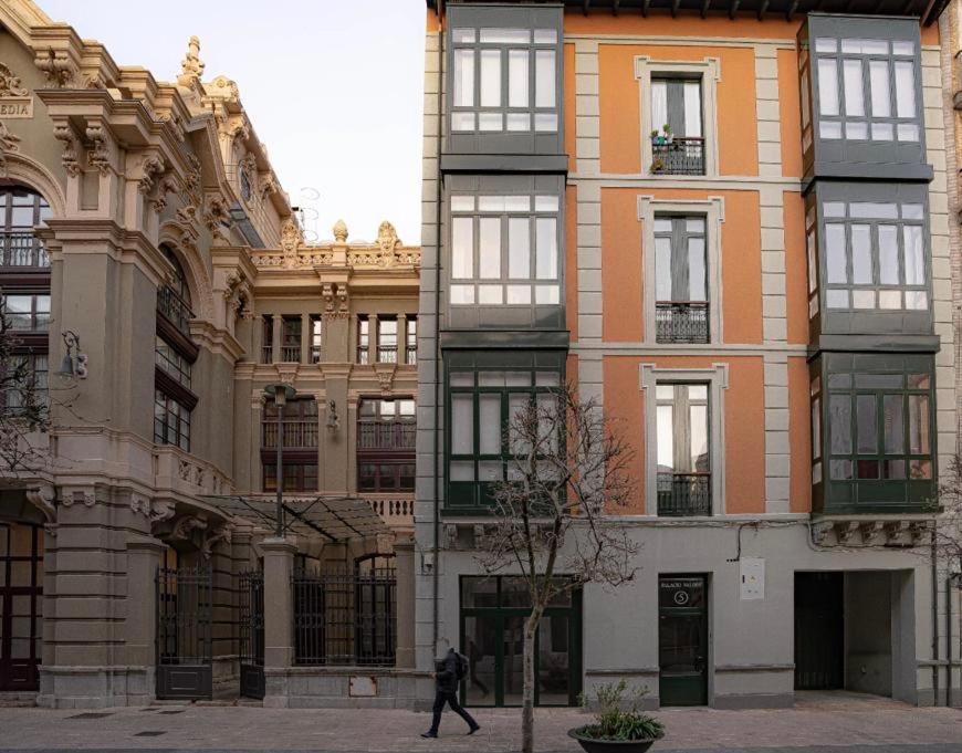 Apartamento Palacio Valdés, centro Avilés, con parking في أفيليس: رجل يمشي امام مبنى
