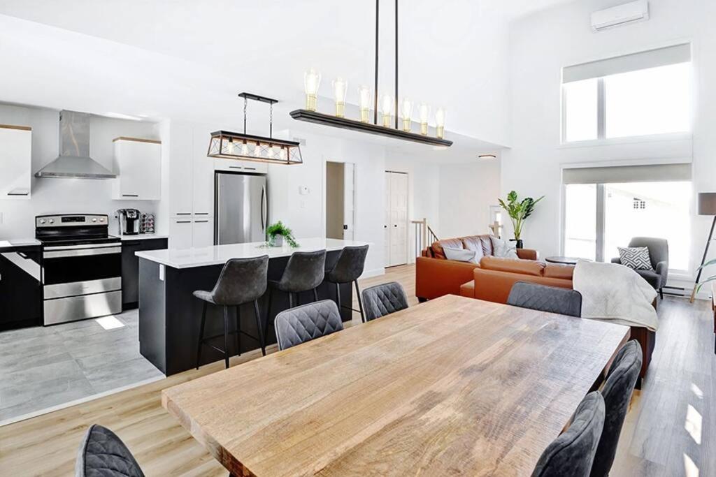 a kitchen and a living room with a table and chairs at 15 Chemin des Cascades in Stoneham
