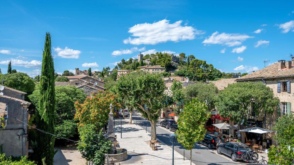 a street in a town with trees and buildings at La Terrasse d'Eygalières in Eygalières