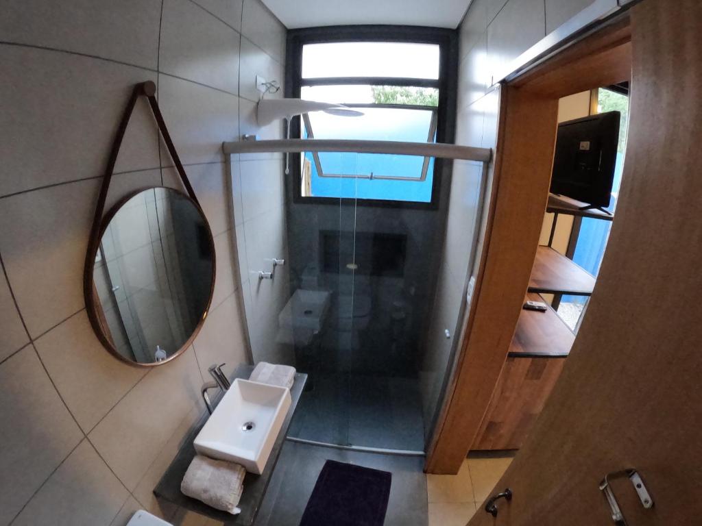 a small bathroom with a mirror and a sink at Pousada Low Tide maresias in Maresias