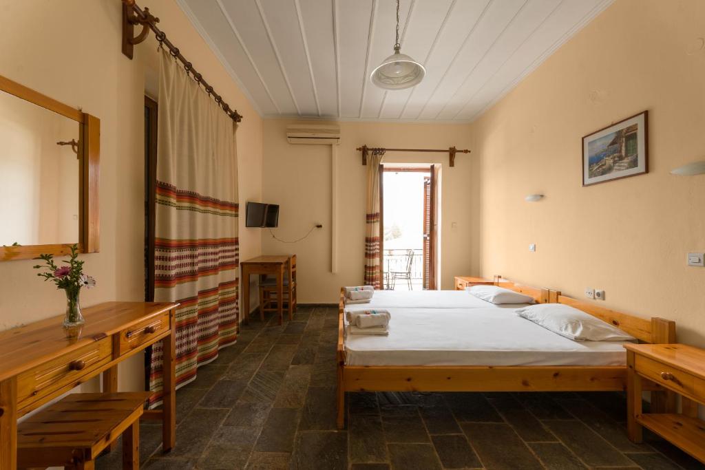 a bedroom with a bed and a table and a mirror at KASTRO AGGELIKI in Kardamyli