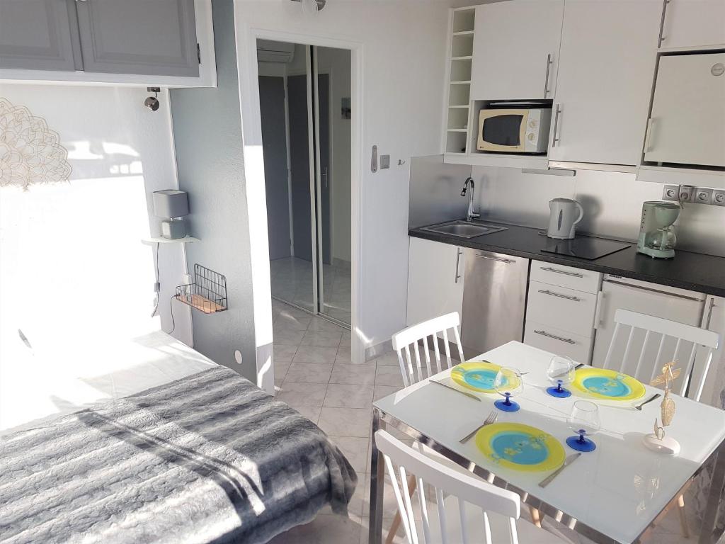 une cuisine avec une table avec deux assiettes dessus dans l'établissement Studio Village Naturiste Caprice, au Cap d'Agde