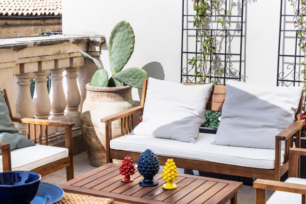 patio con divano e tavolo con cactus di Guest House Aurispa a Noto