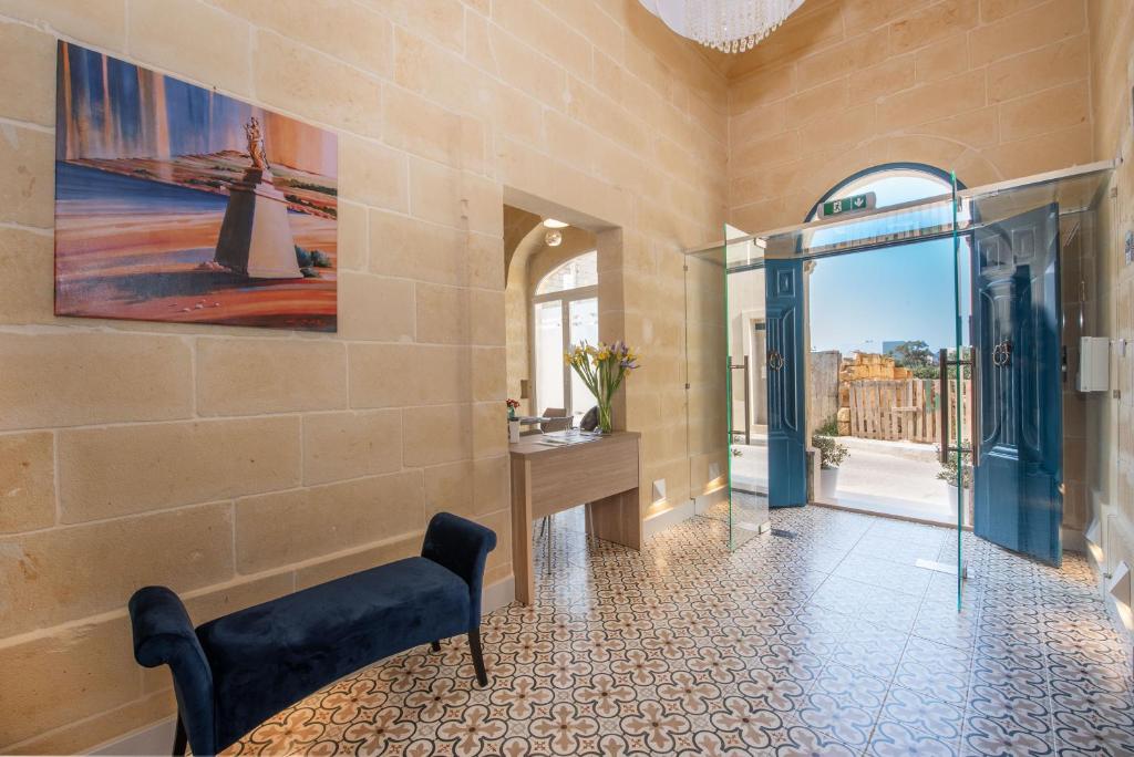 a lobby with a bench and a painting on the wall at Georges Boutique Living in Xagħra