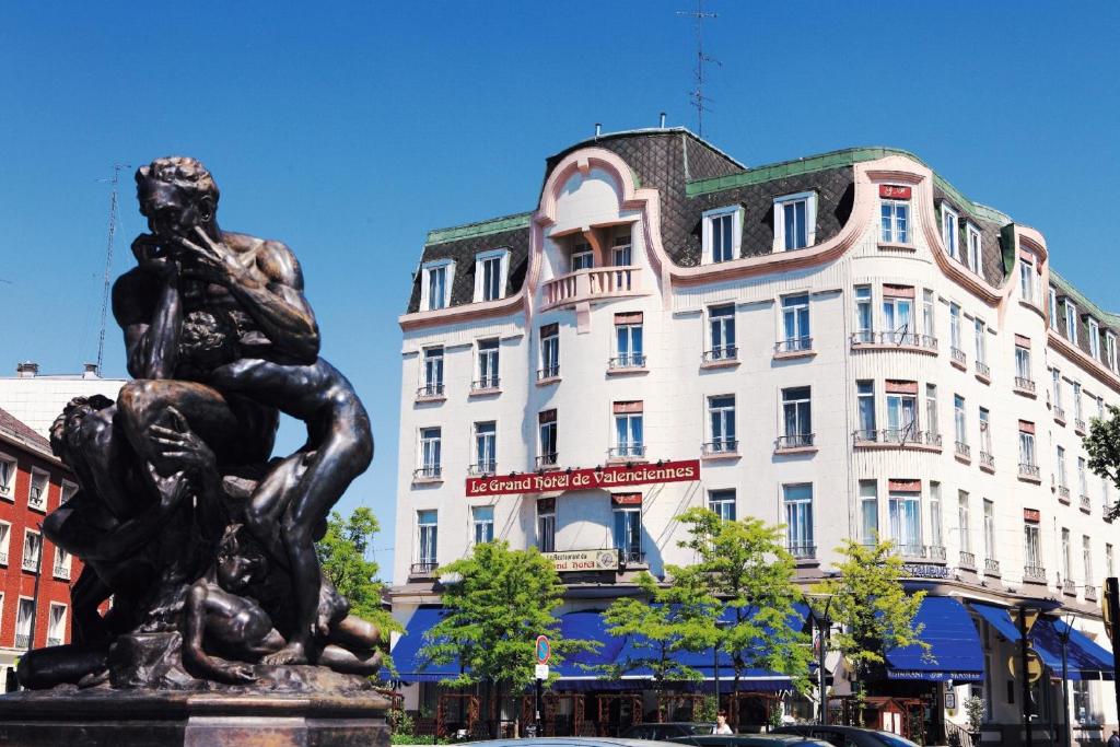 une statue d'une femme devant un bâtiment dans l'établissement Le Grand Hotel, à Valenciennes