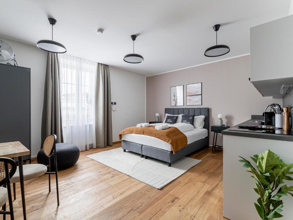 a bedroom with a king sized bed and a kitchen at limehome Villach Gerbergasse in Villach