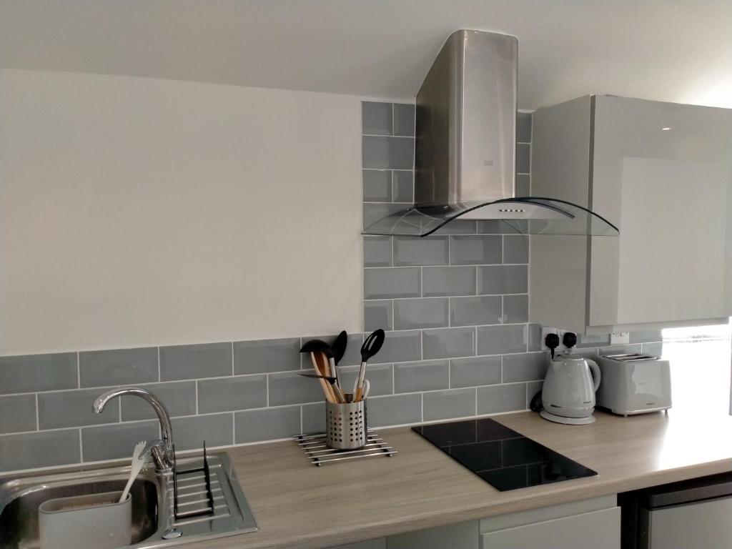 a kitchen with a sink and a counter top at Carriage Lodge - Stunning Apartment with parking in Wateringbury