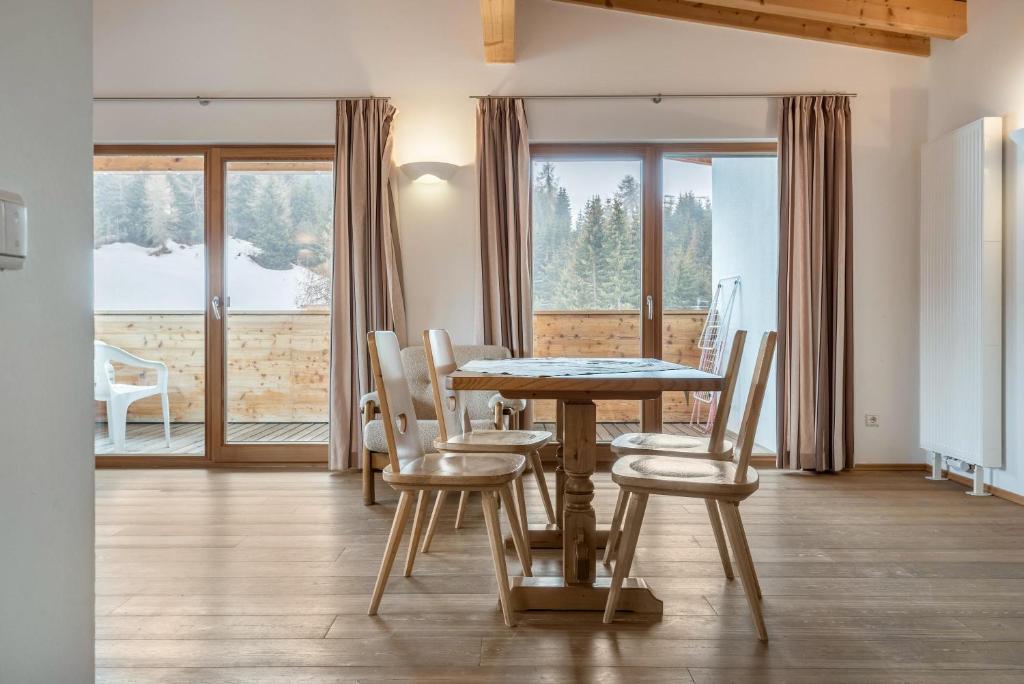 comedor con mesa, sillas y ventana en Ferienparadies Sabina Birke, en Alpe di Siusi
