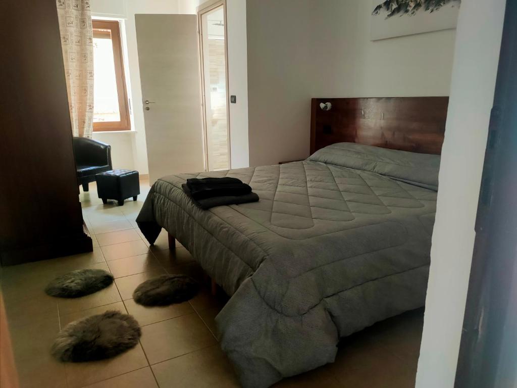 una camera da letto con un letto con due cuscini sul pavimento di Locanda mami ad Aosta