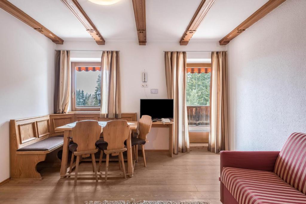 a living room with a table and chairs and a couch at Ferienparadies Sabina Compatsch in Alpe di Siusi